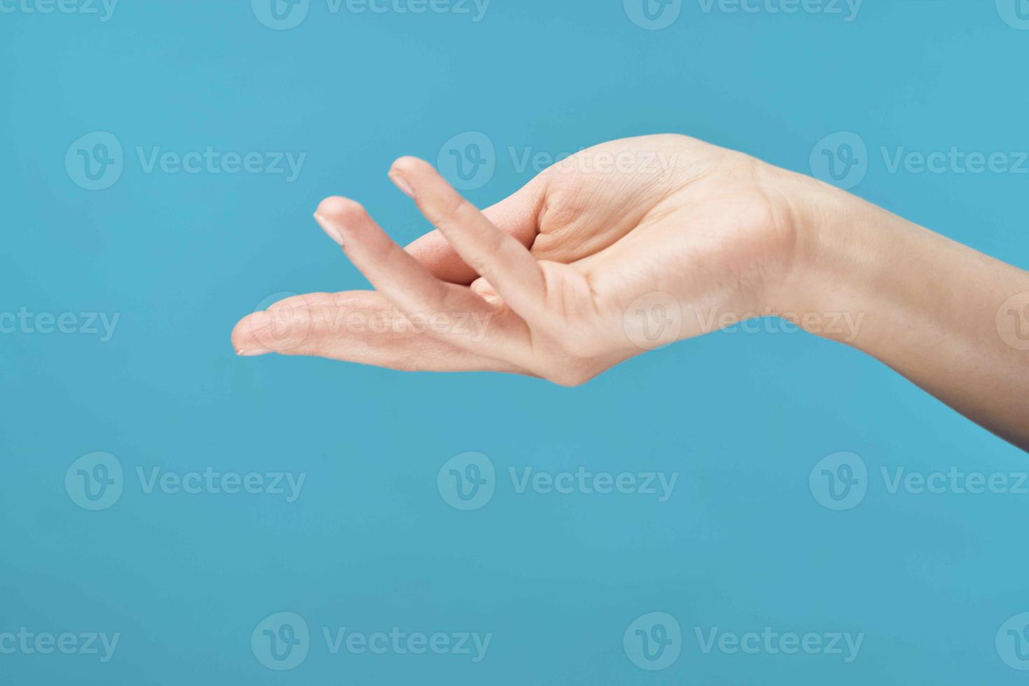 weiblich Hand Haut Pflege Sahne Blau Hintergrund Nahansicht foto