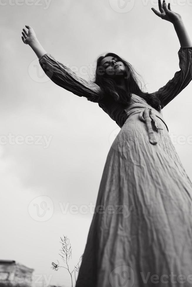 ziemlich Frau im Kleid gestikulieren mit Hände posieren schwarz und Weiß Foto