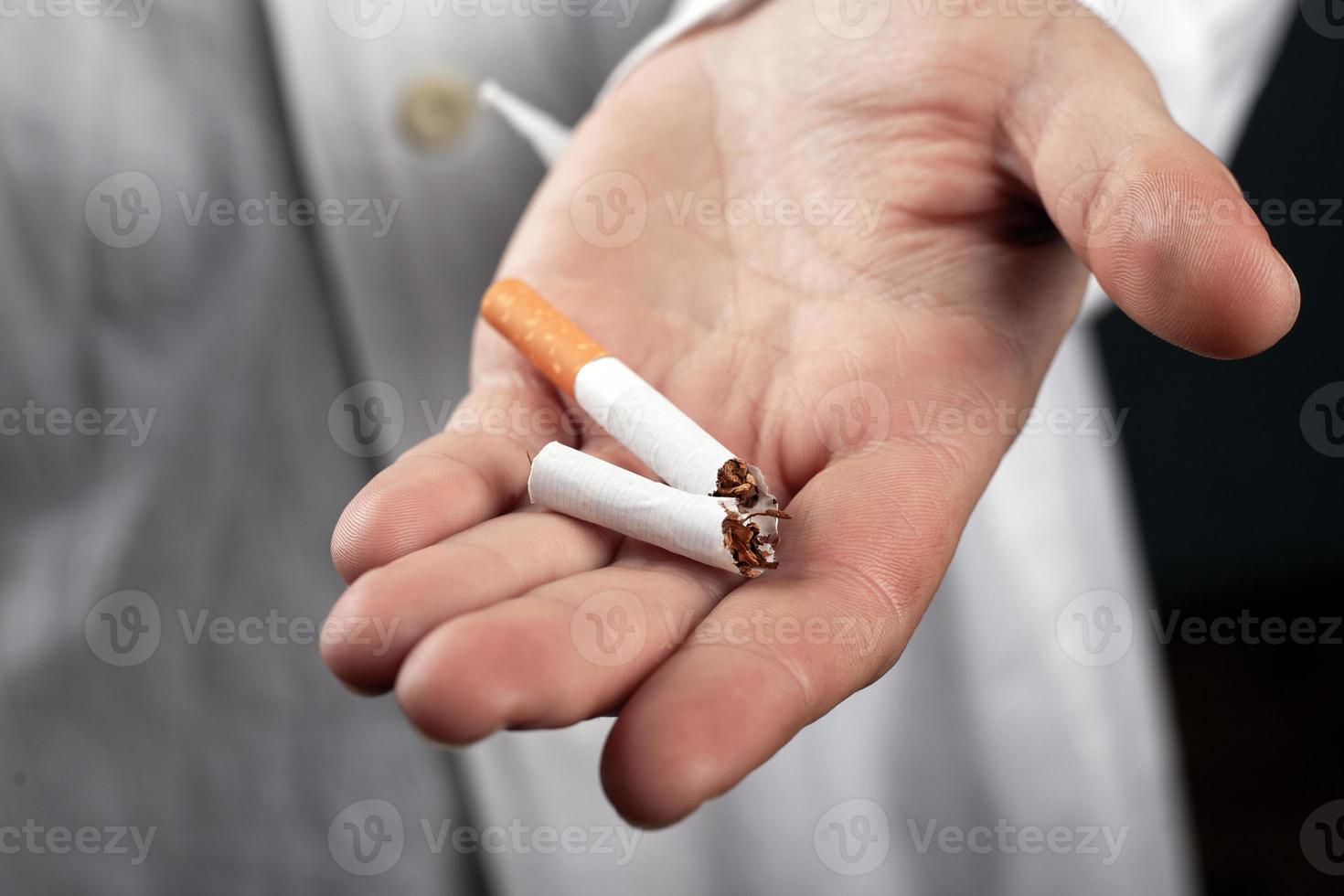 zerbrochene Zigarette in der Hand einer Nahaufnahme eines Arztes foto