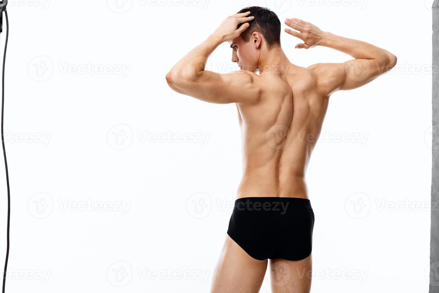 Kerl mit sportlich Körperbau halt Hände hinter Kopf zurück Aussicht foto