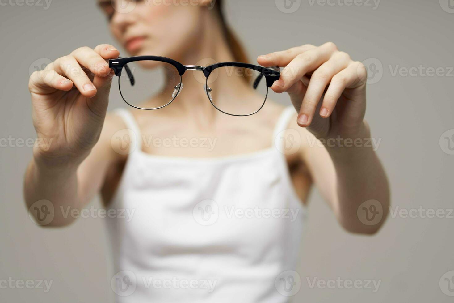 Frau Brille im das Hände von Astigmatismus Studio Behandlung foto