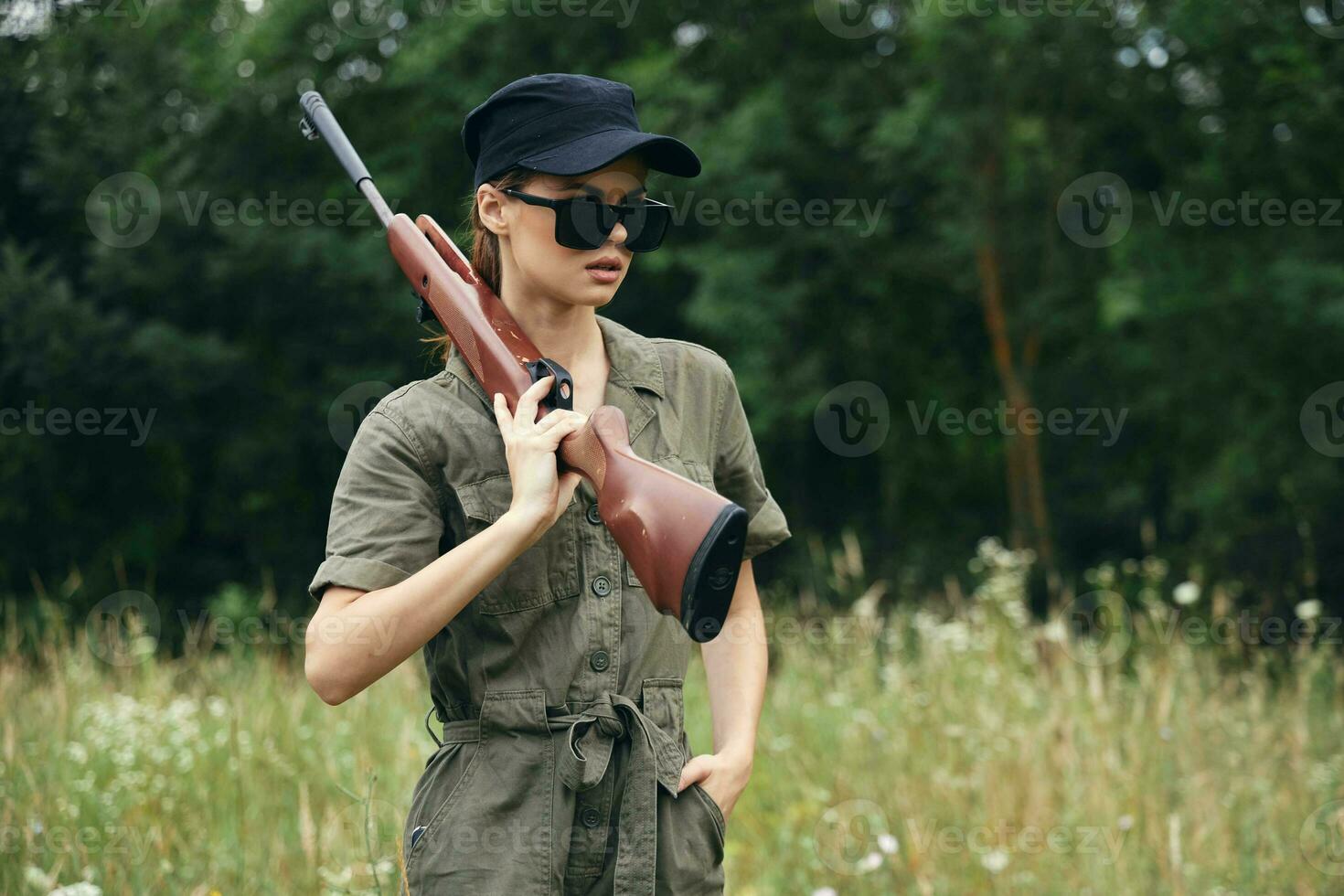 Militär- Frau Frau mit Waffen im dunkel Brille Grün Overall frisch Luft foto