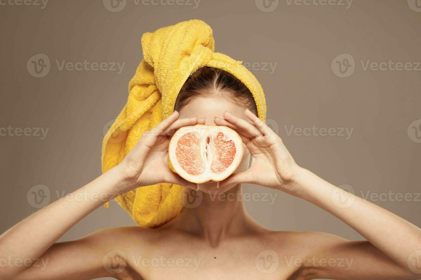 Frau mit ein Handtuch auf ihr Kopf Grapefruit im ihr Hände Gesundheit Vitamine entblößt Schultern foto