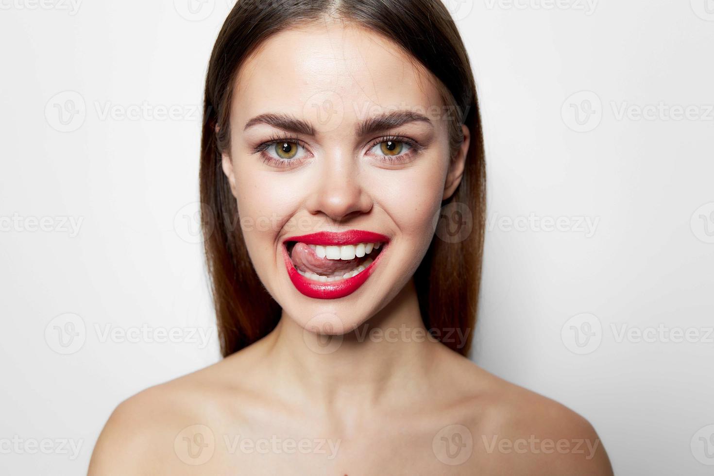 Frau mit entblößt Schultern rot Lippen zeigen Zunge Grimasse Studio foto