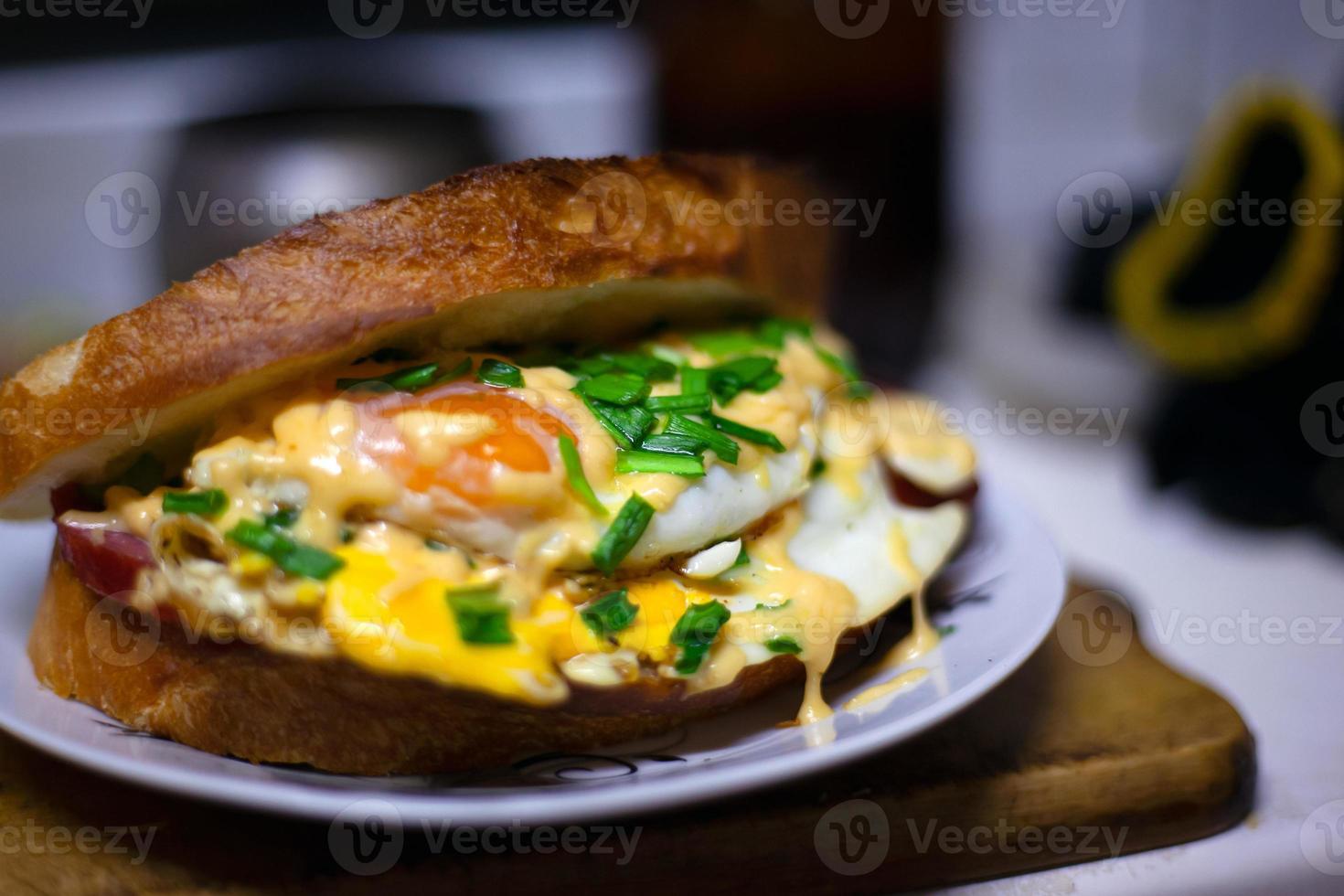 Gebratenes Sandwich mit Wurst, Ei, Käse und Frühlingszwiebeln foto