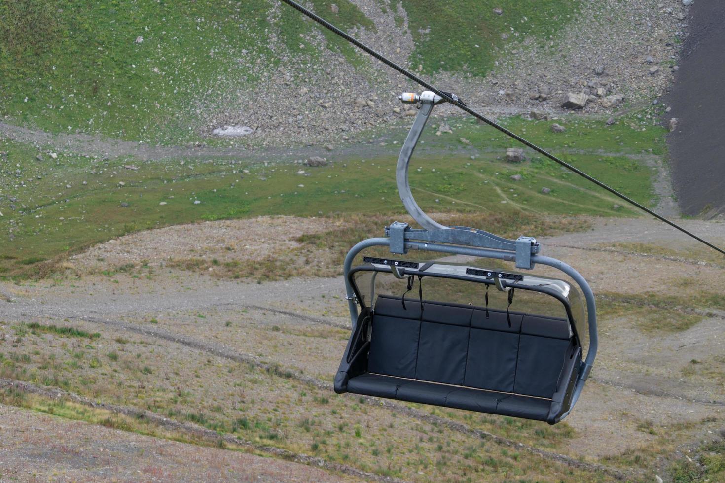 Skiliftstuhl auf einem Kabel mit Berg im Hintergrund in Sotschi, Russland foto