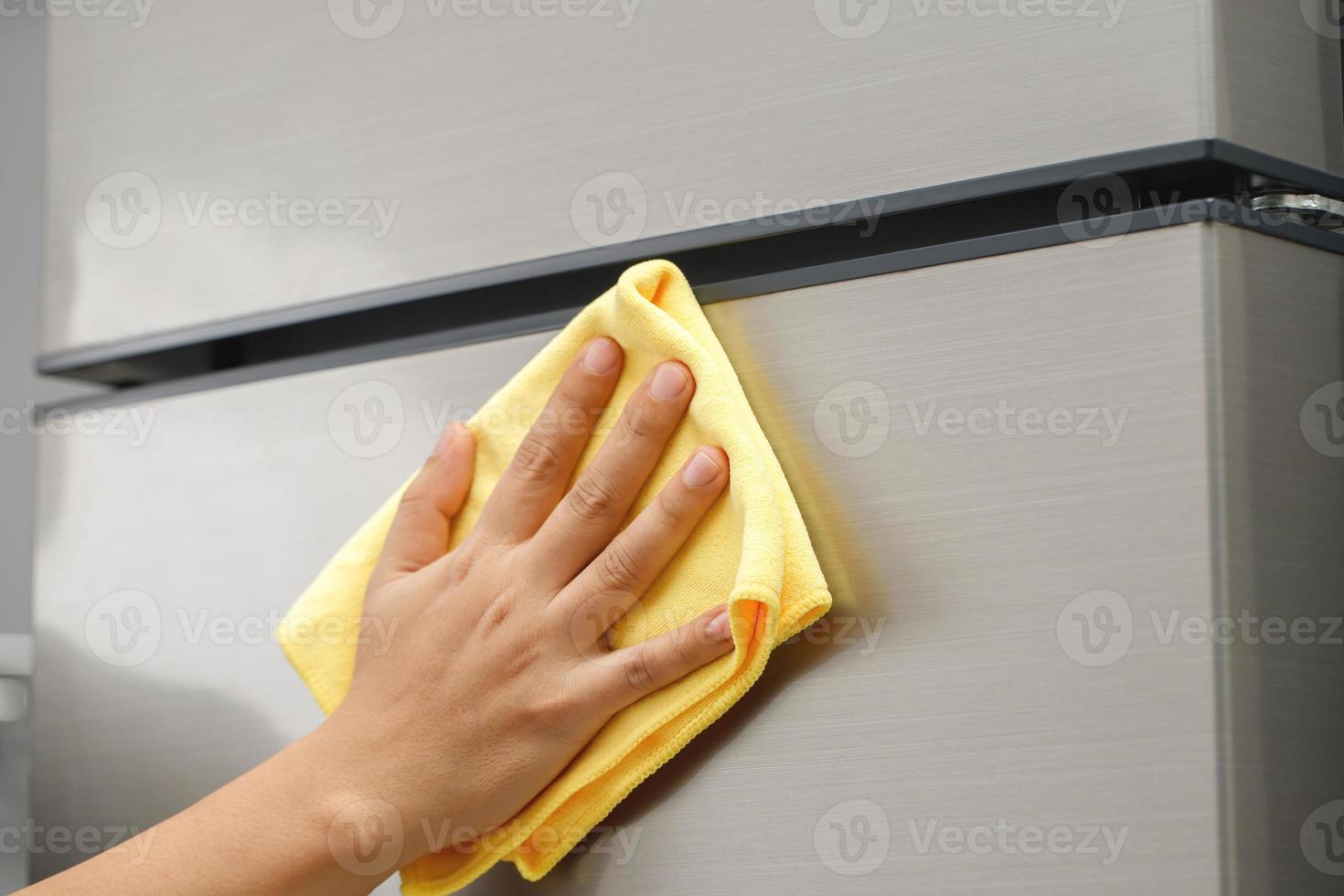 Angestellte verwenden ein Stoff zu sauber das Kühlschrank. foto
