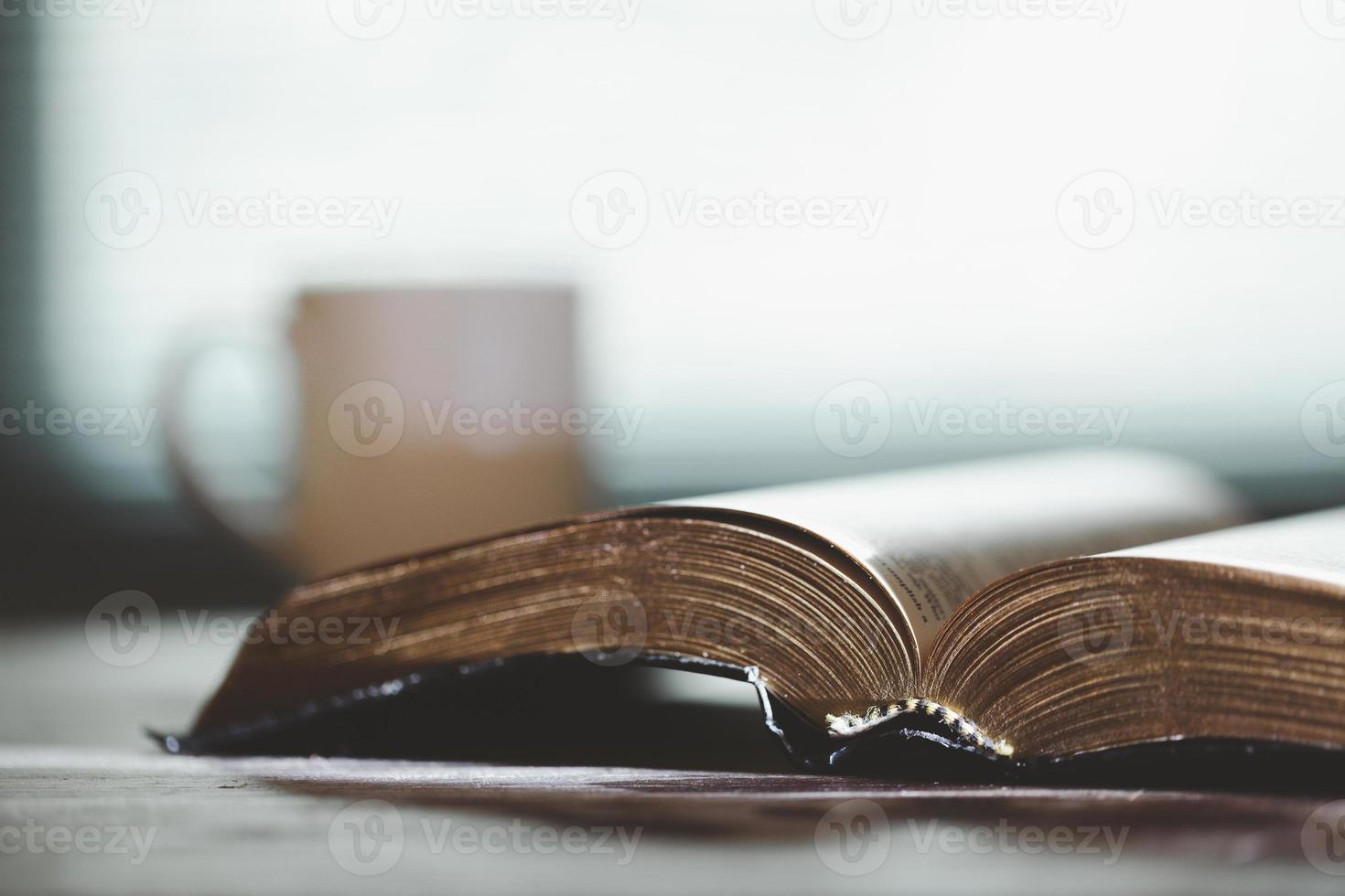 heilig Bibel Buch zum Bildung auf hölzern Tabelle mit Hintergrund. Christian katholisch mit evangelisch Anbetung und beten im Kirche. Konzept von Lernen Über Vertrauen Gott und Religion, Jesus spirituell. foto