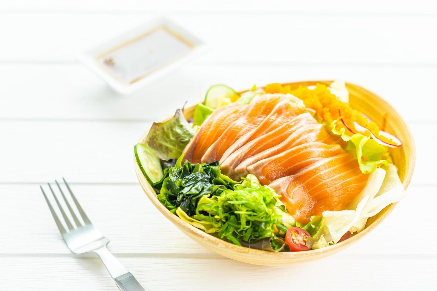 roher frischer Lachs Fischfleisch Sashimi mit Seetang und anderem Gemüsesalat foto