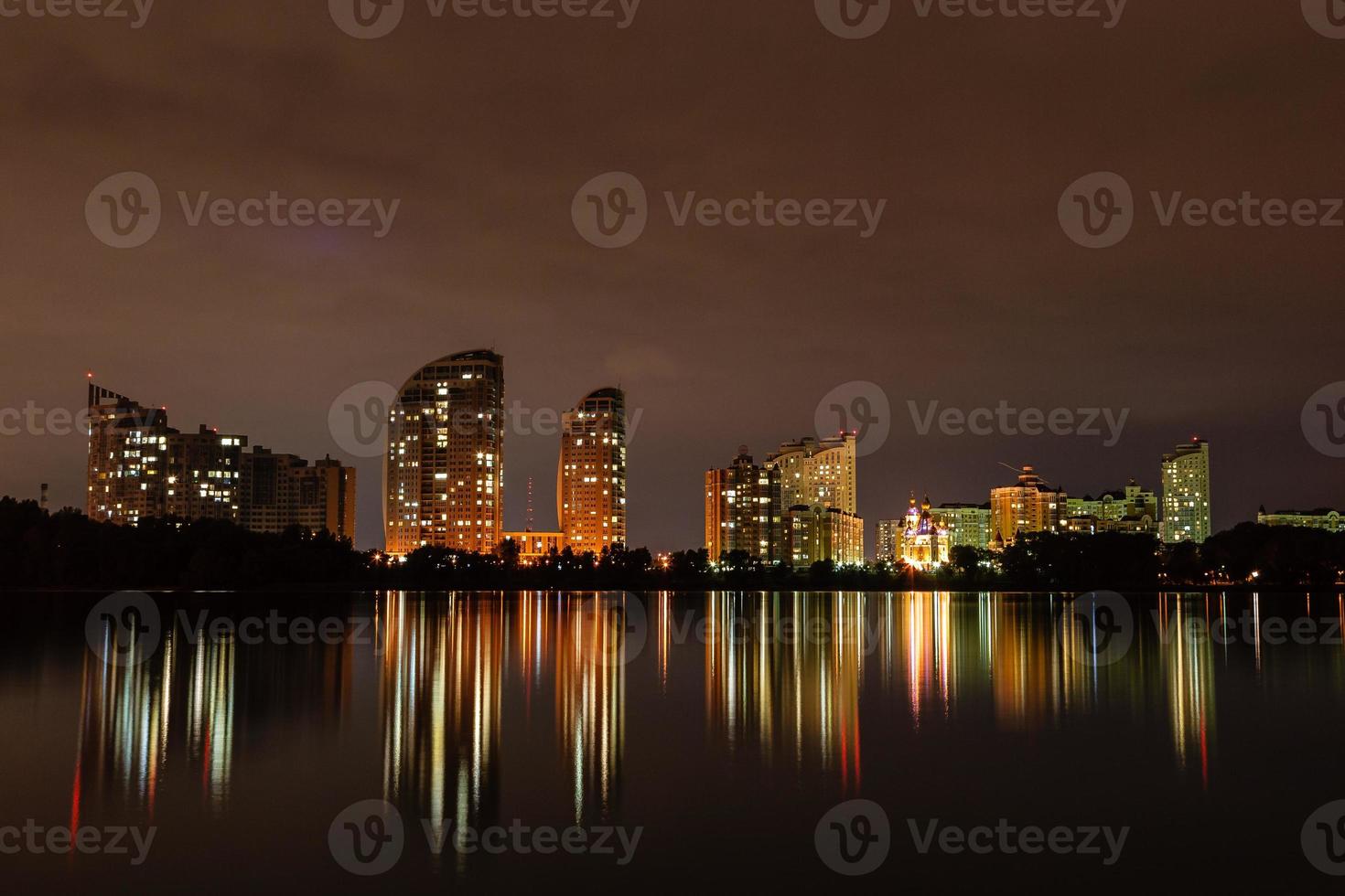 Nachtstadt mit Reflexion von Häusern im Fluss foto