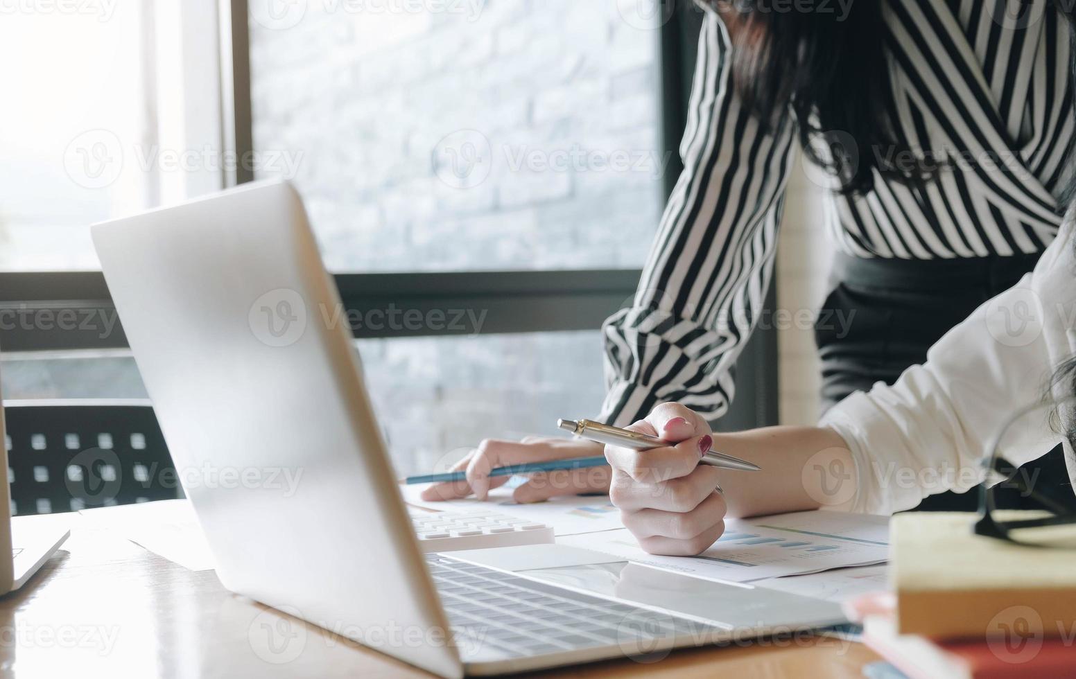 zwei Mitarbeiter, die einen Laptop betrachten foto