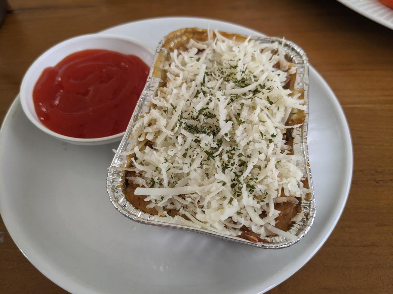 Zeder Käse und Mozzarella auf das geröstet Rindfleisch Lasagne mit Chili Soße. das Foto ist geeignet zu verwenden zum Essen Hintergrund, Poster und Essen Inhalt Medien.