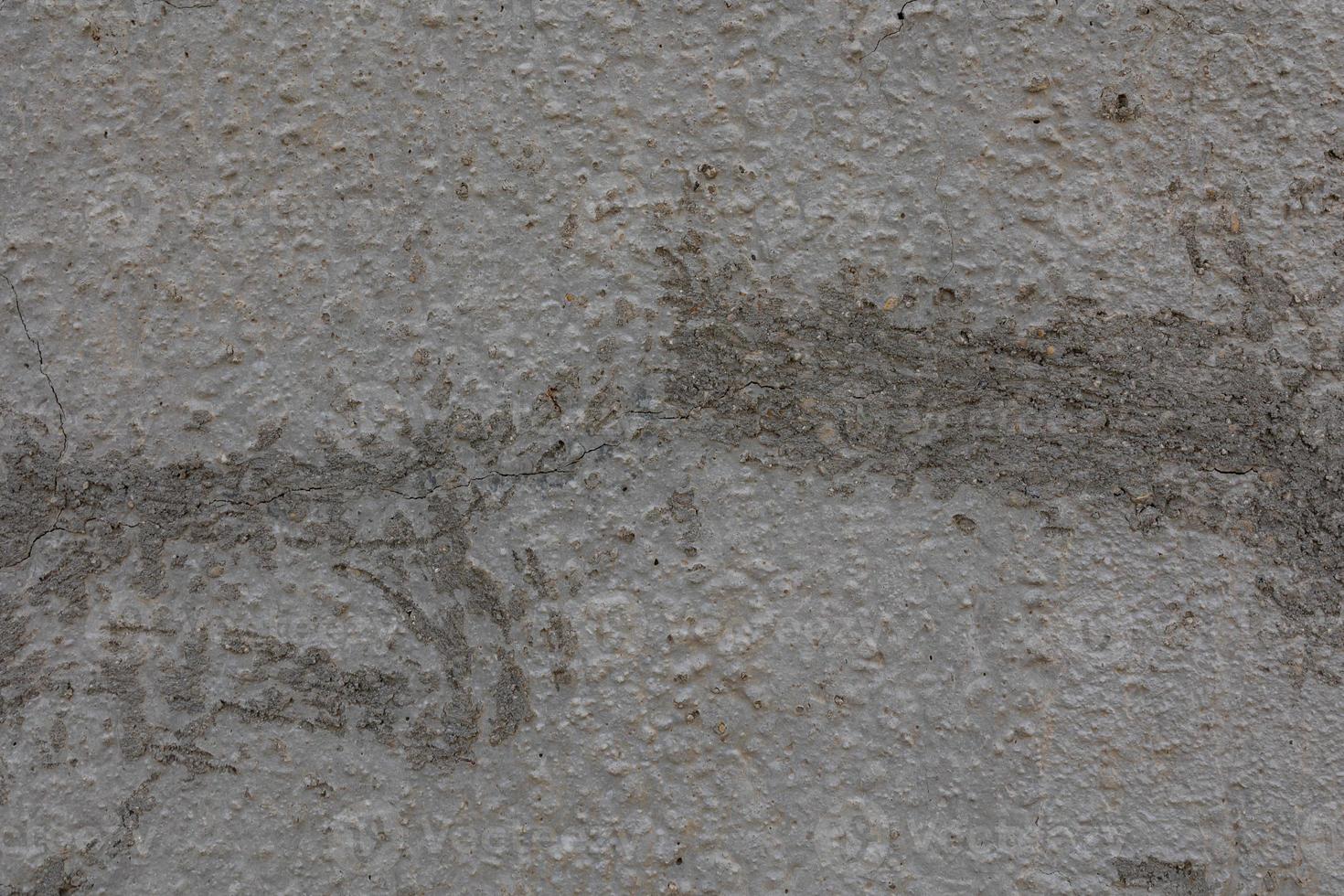 Hintergrund von alt grau Mauer mit geknackt Gips im Nahansicht foto