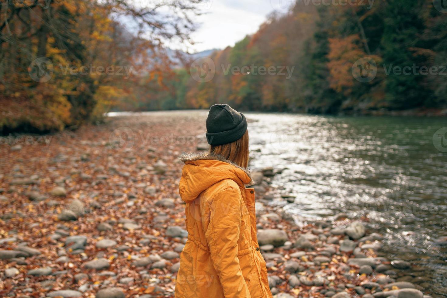 Frau Spaziergänge entlang das Fluss Herbst Wald Natur Berge foto