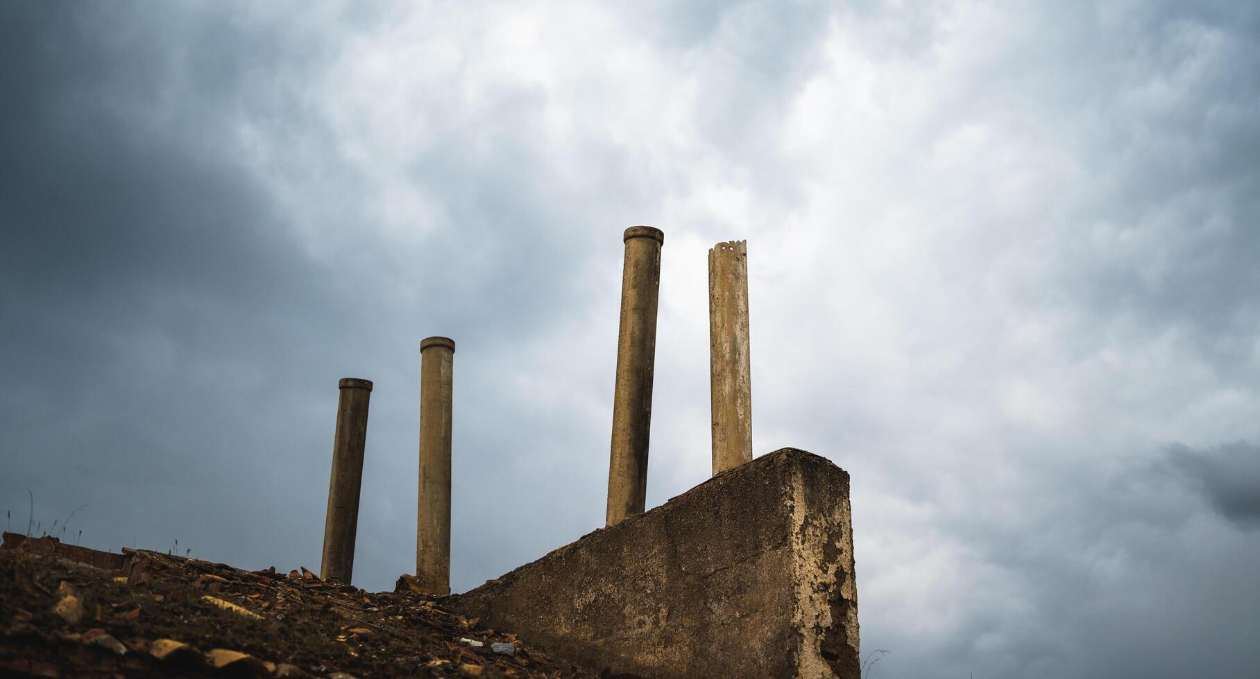 Schornsteine auf einem zerstörten Dach mit einem dramatischen Sturmhimmel foto