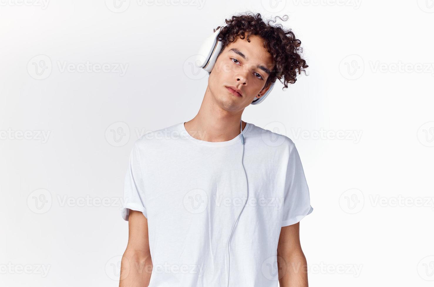 Teenager T-Shirt und im Kopfhörer auf ein Licht Hintergrund Neu Technologie Modell- foto