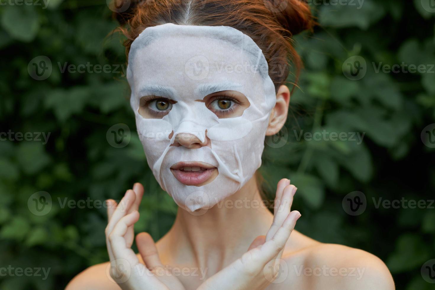 Porträt von ein Mädchen Anti-Falten Maske Natur Hände in der Nähe von das Gesicht von dünn Stoff Haut Pflege Blätter im das Hintergrund foto
