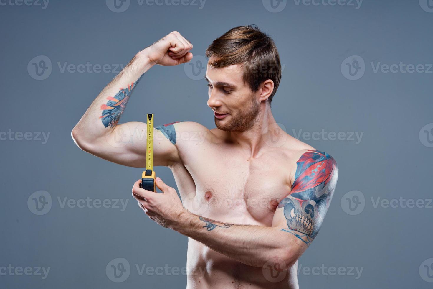 tätowiert Mann muskulös Bodybuilder Fitness grau Hintergrund foto