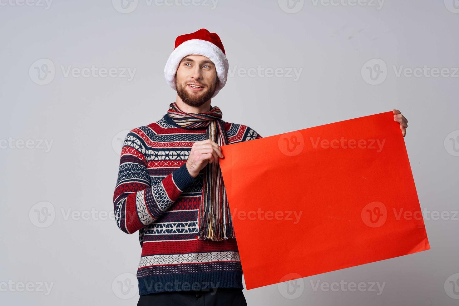 heiter Mann im ein Weihnachten Hut mit rot Attrappe, Lehrmodell, Simulation Poster Licht Hintergrund foto