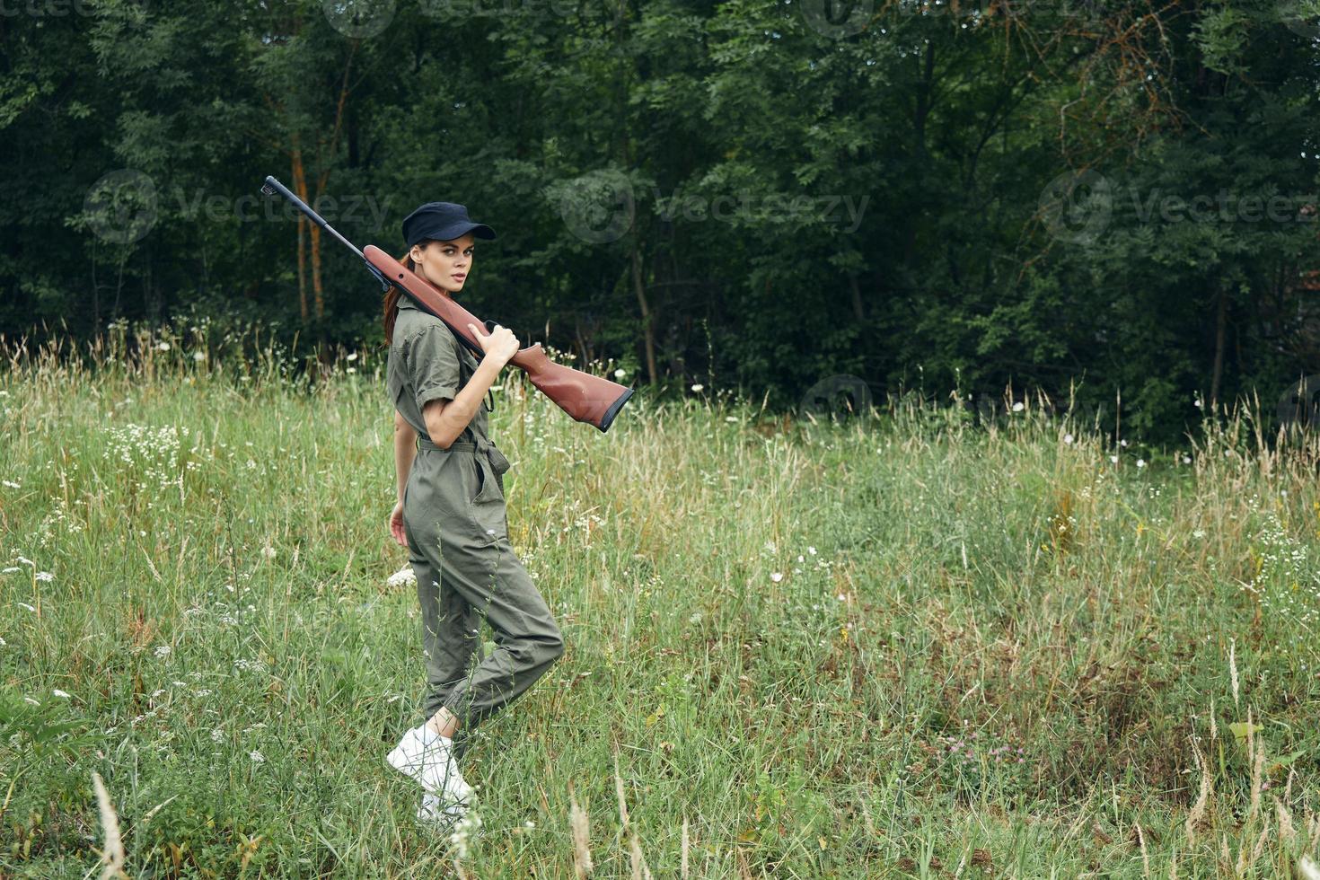 Militär- Frau Grün Overall mit Waffen auf Schulter frisch Luft von Natur foto