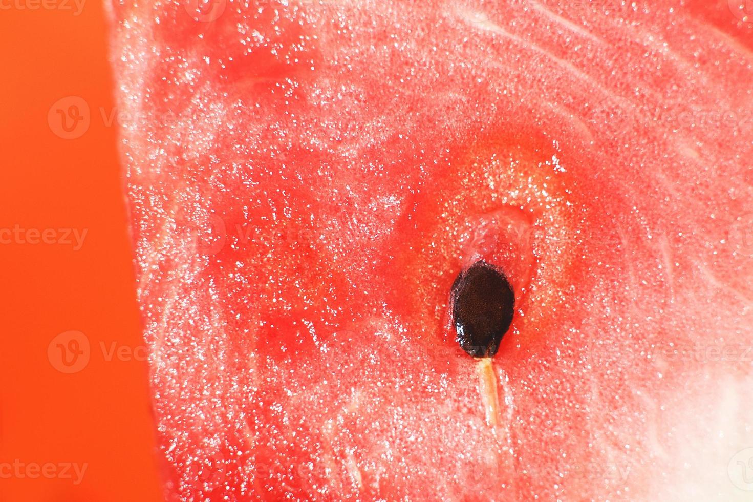 Scheibe von Wassermelone auf Orange Hintergrund Nahansicht. Wassermelone Samen Makro foto