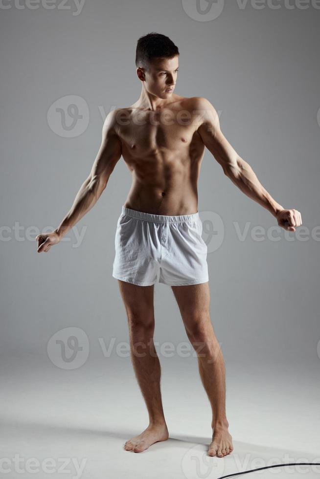 ein Athlet im kurze Hose Gesten mit seine Hände im ein hell Zimmer foto