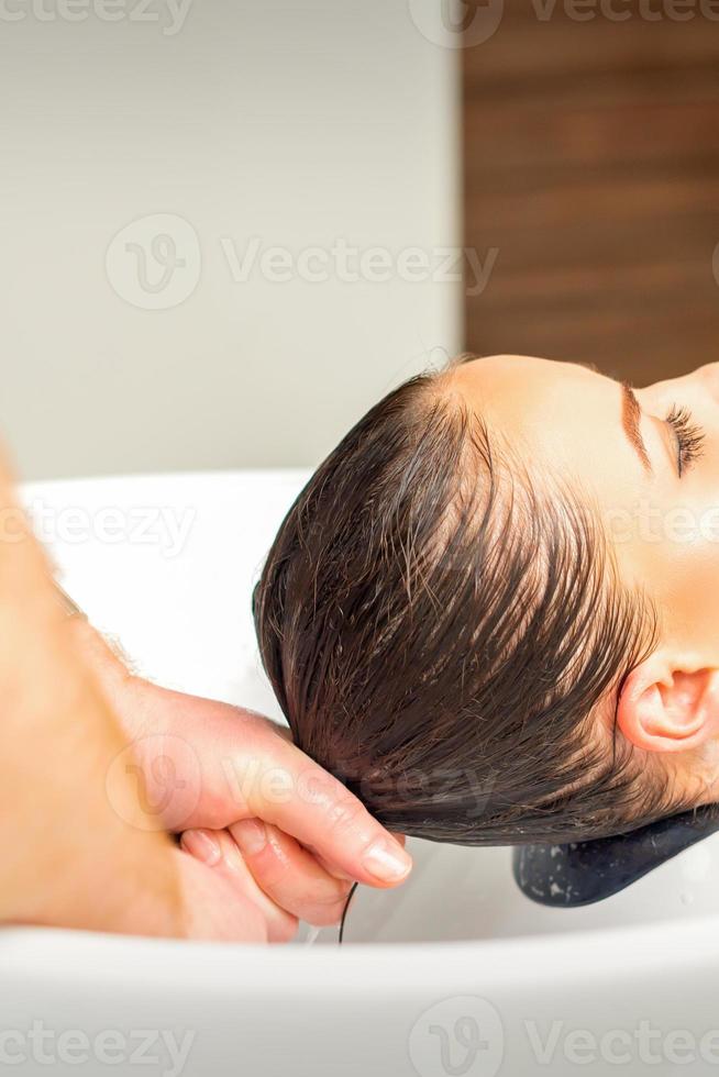 Friseur Waschen Haar von Klient foto