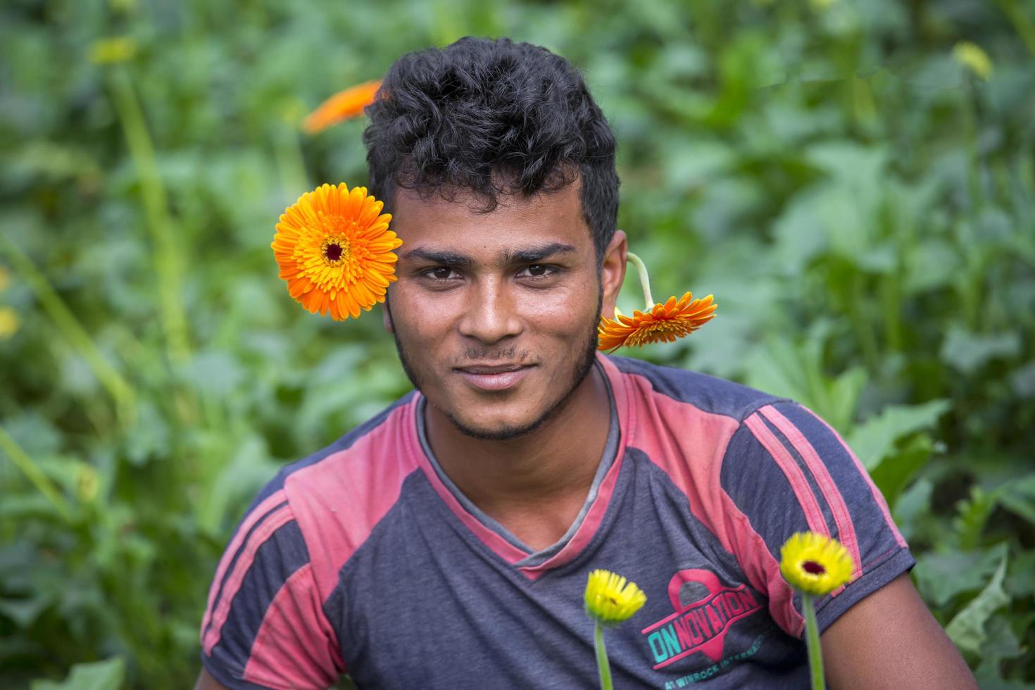 Bangladesch Dezember 07, 2017 ein Gerbera Blume Farmer sieht aus beim das Kamera während neigen zu das Blumen im seine Garten beim Savar, dhaka. foto