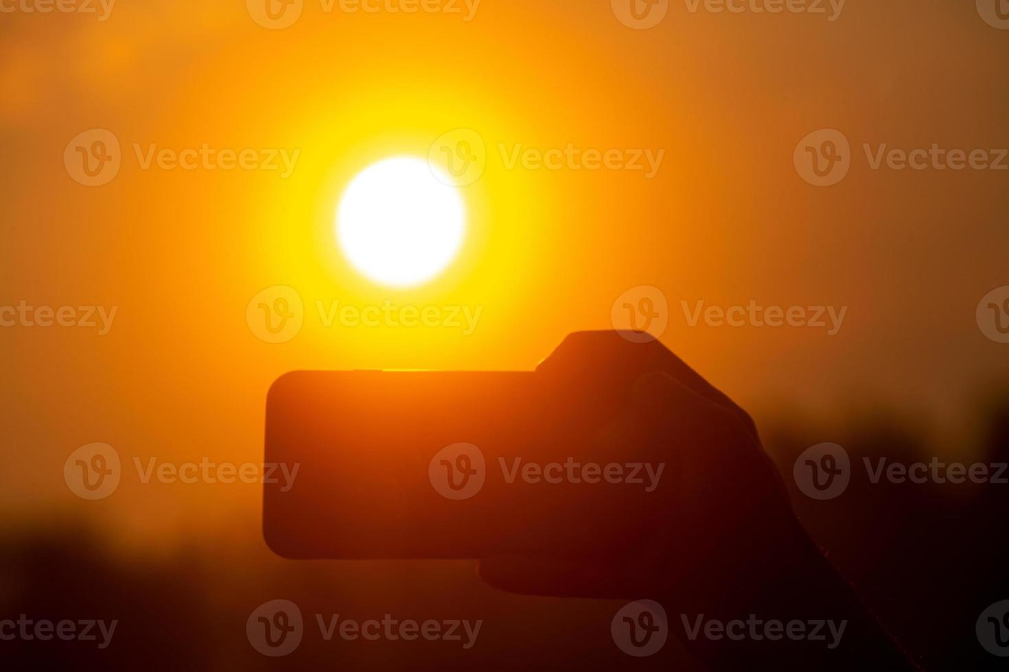 nehmen Bilder mit ein Handy, Mobiltelefon Kamera beim Sonnenaufgang. Selfie Picks oben mit ein Handy, Mobiltelefon Kamera im das golden Licht von Sonnenaufgang. foto
