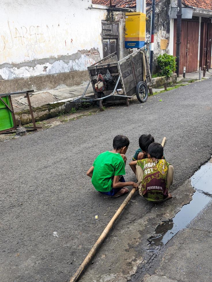 Surabaya, Indonesien - - April, 2023 - - ein etwas asiatisch Jungs versammelt halten Bambus foto