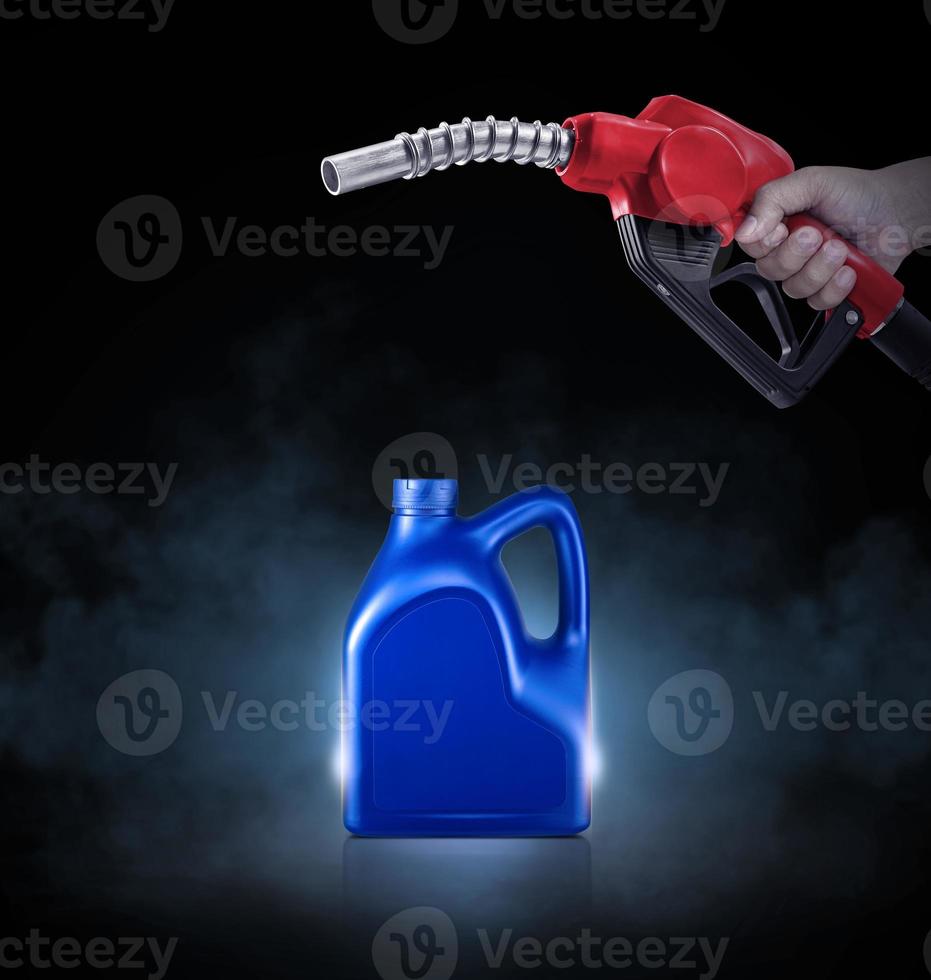 Hände halten Treibstoff Düse und Blau Flasche von Motor Öl auf schwarz Hintergrund mit Rauch foto