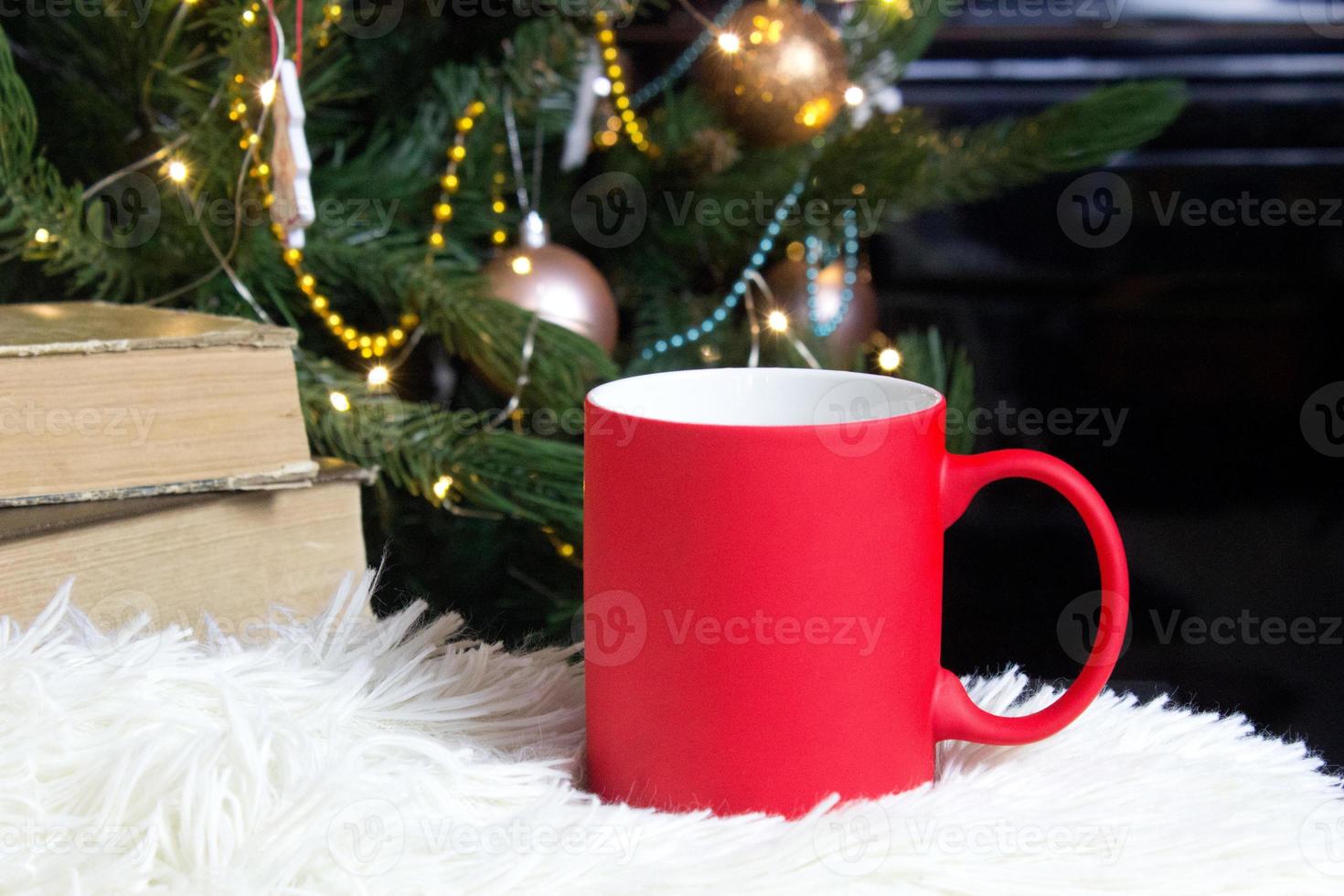 leer rot Becher mit Weihnachten Baum auf Hintergrund, Matte Tee oder Kaffee Tasse mit Weihnachten und Neu Jahr Dekoration, horizontal spotten oben mit Keramik Becher zum heiß Getränke, leer Geschenk drucken Vorlage foto