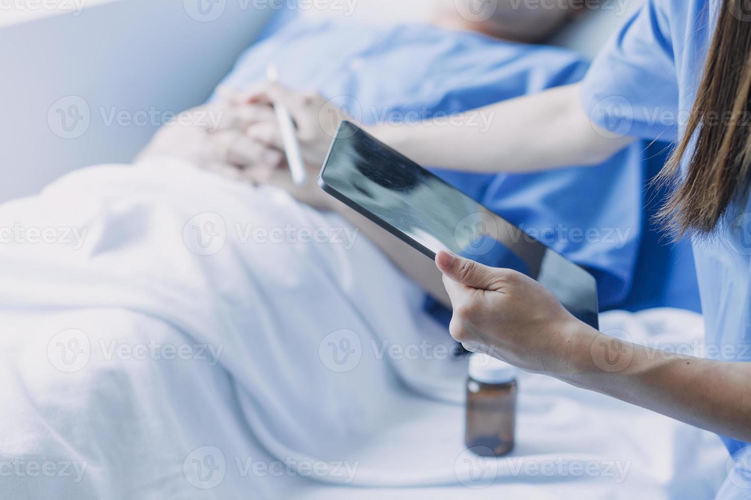 Seite Aussicht von vielfältig Ärzte Prüfung asiatisch weiblich geduldig im Bett im Station beim Krankenhaus. foto