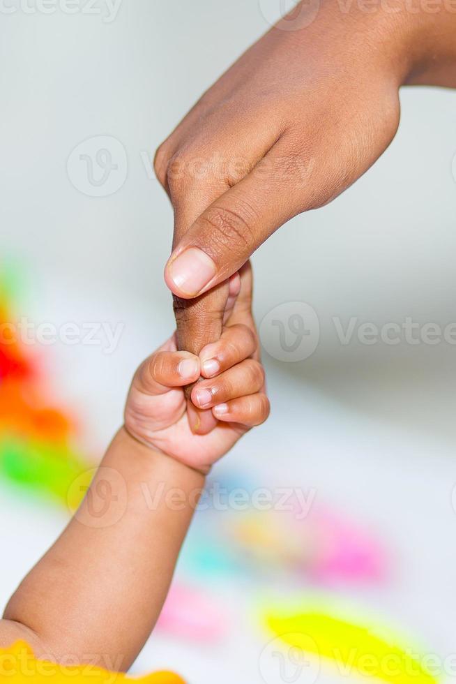 ein asiatisch Babys Hand halten ihr Mutter Finger foto