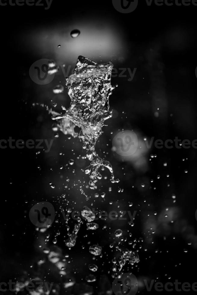 Wasser Flüssigkeit planschen auf isoliert schwarz Hintergrund. foto