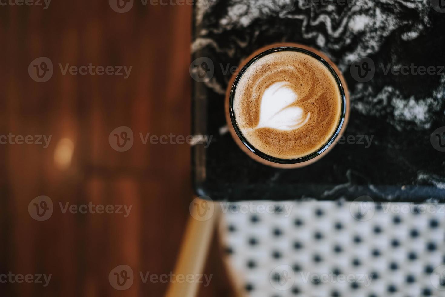 ein Tasse von Kaffee mit Latté Kunst auf schwarz Marmor Tabelle foto