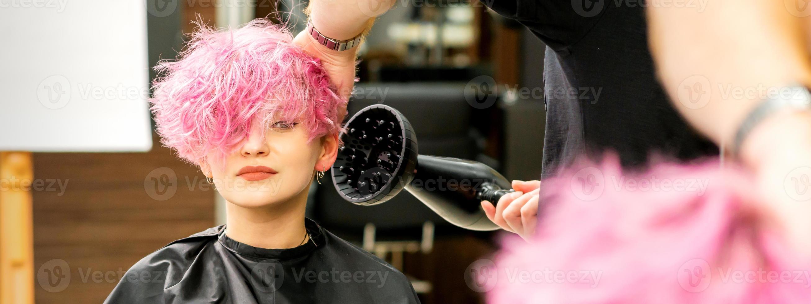 Friseur Trocknen Rosa Haar von Klient foto