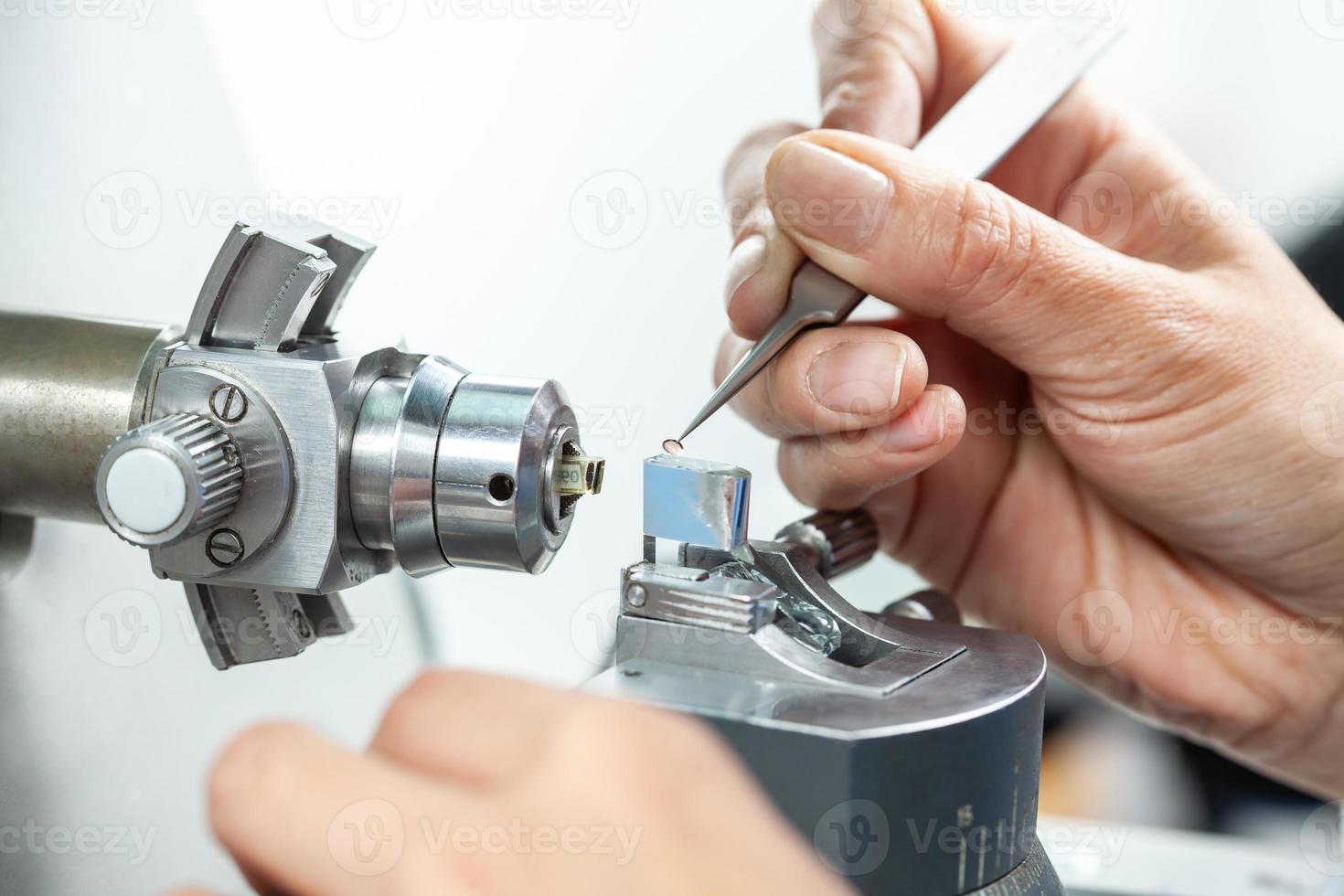 Nahansicht von ein weiblich Wissenschaftler Platzierung ein Stichprobe auf ein Getriebe Elektron Mikroskopie Gitter foto