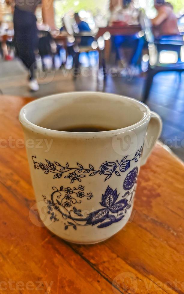 blauer weißer tassentopf mit schwarzem kaffeeholztisch mexiko. foto