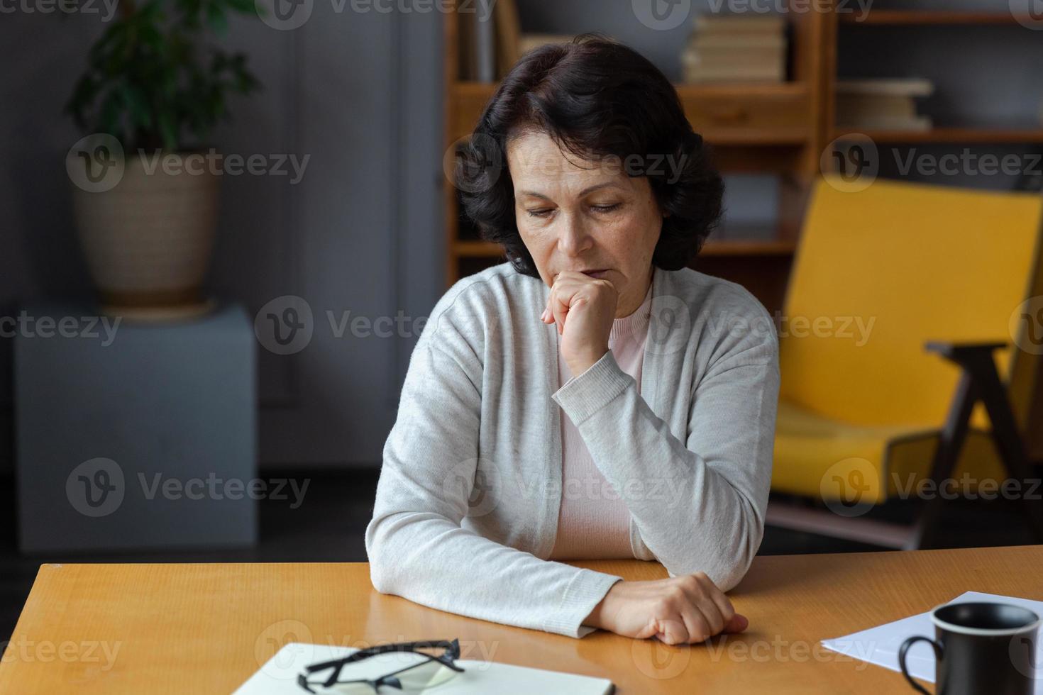 traurig müde krank krank einsam enttäuscht älter Senior Frau Sitzung beim Zuhause allein. unzufrieden reifen Oma erleben Trauer relativ Tod Schlecht Nachricht. betont ältere Dame Leiden von Einsamkeit. foto