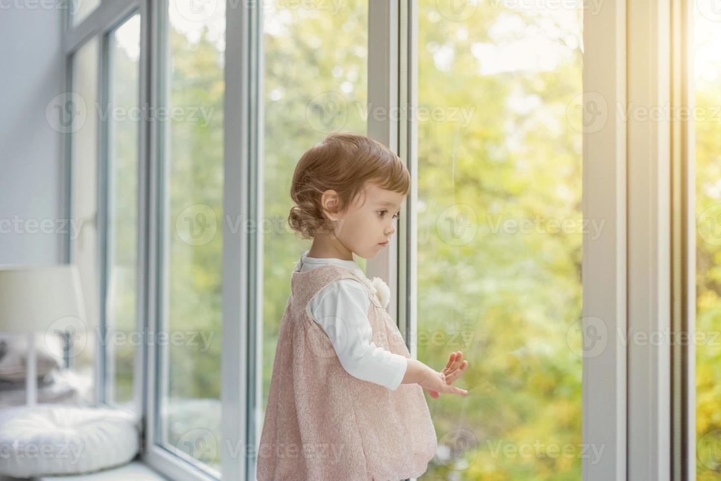 wenig Mädchen Stehen auf Fenster Schwelle foto