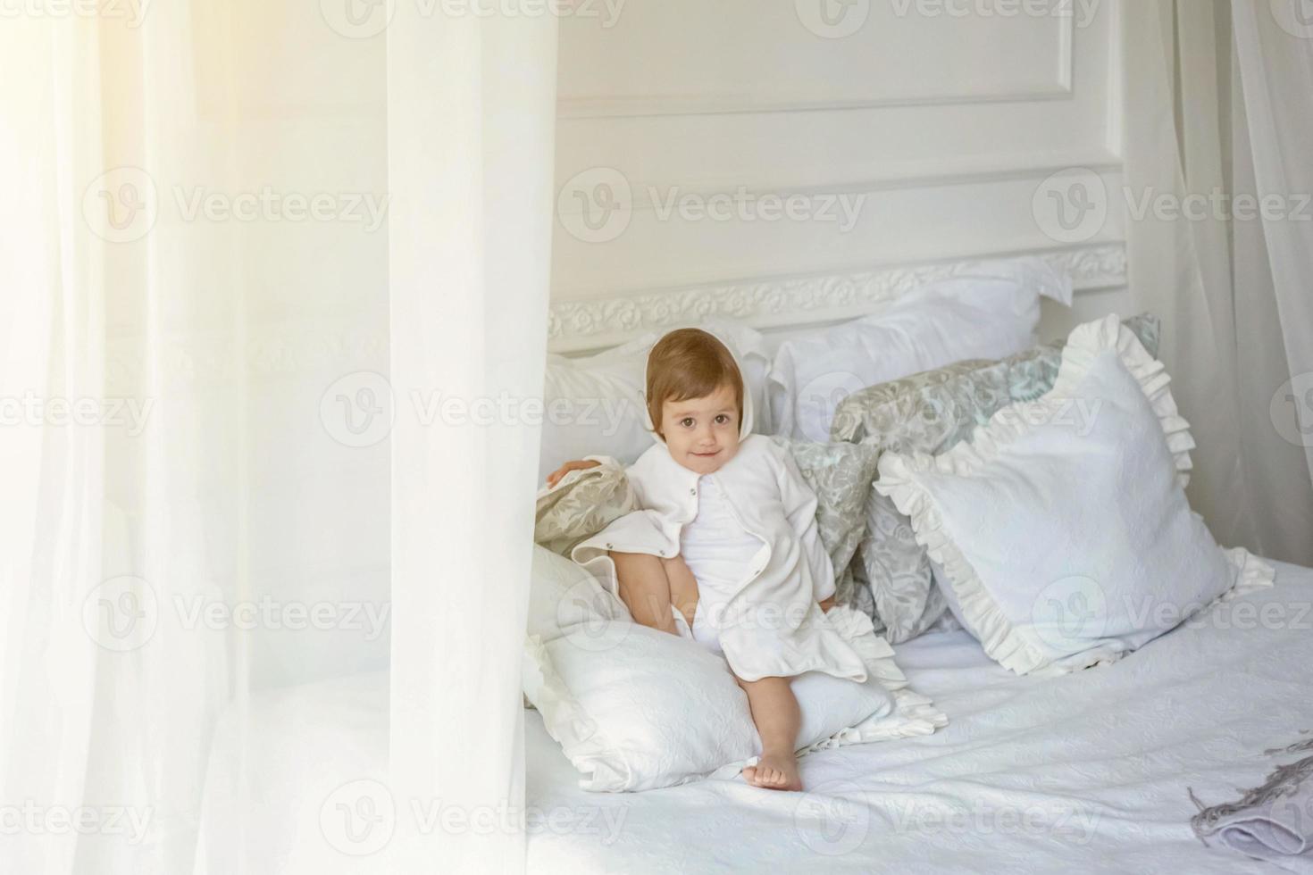 süß wenig Mädchen Springen auf Weiß Bett foto