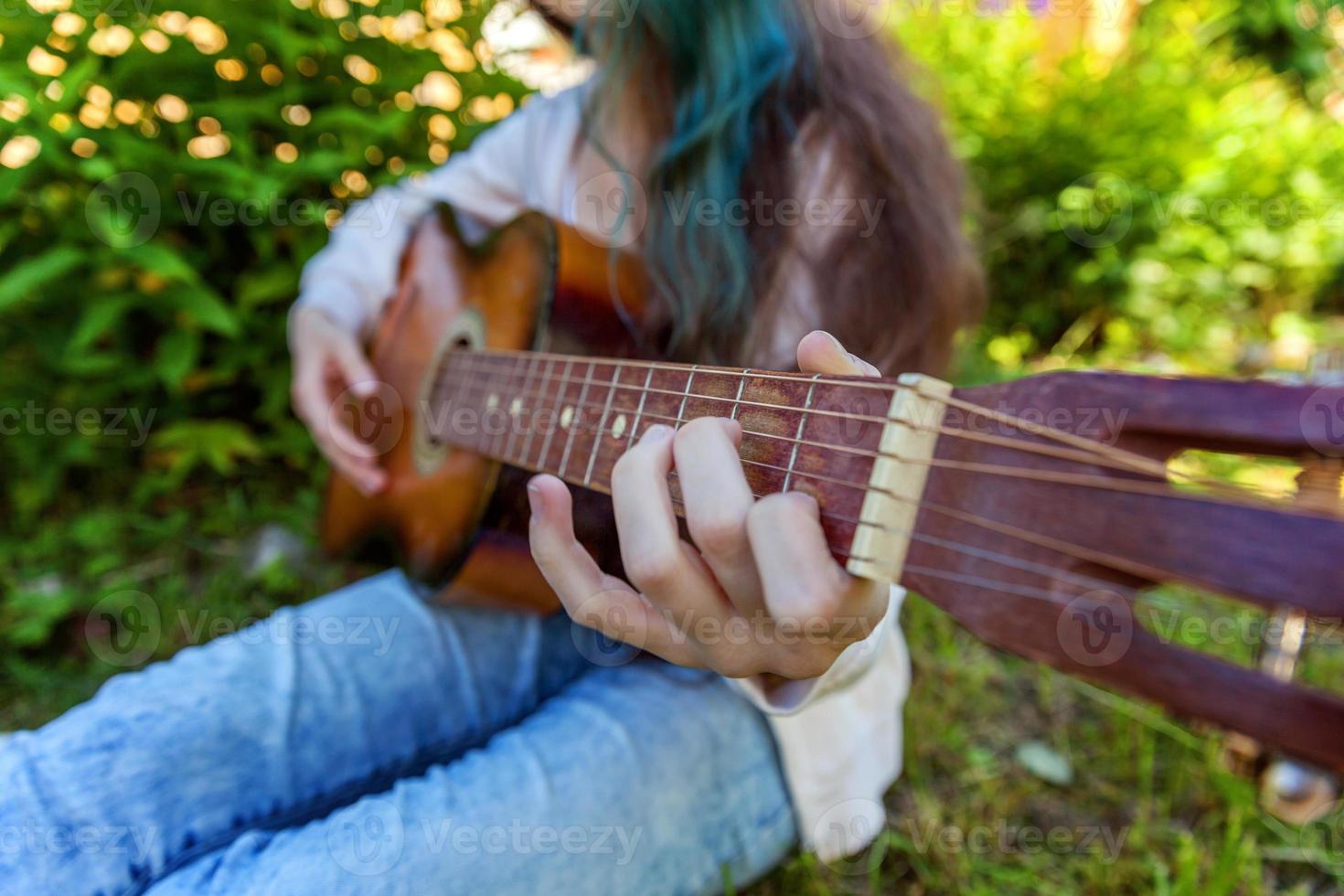 frauenhände, die akustikgitarre spielen foto