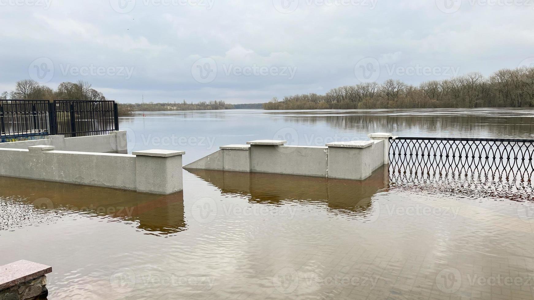 Frühling Überschwemmungen Das überflutet das Wege auf das Fluss Promenade. foto