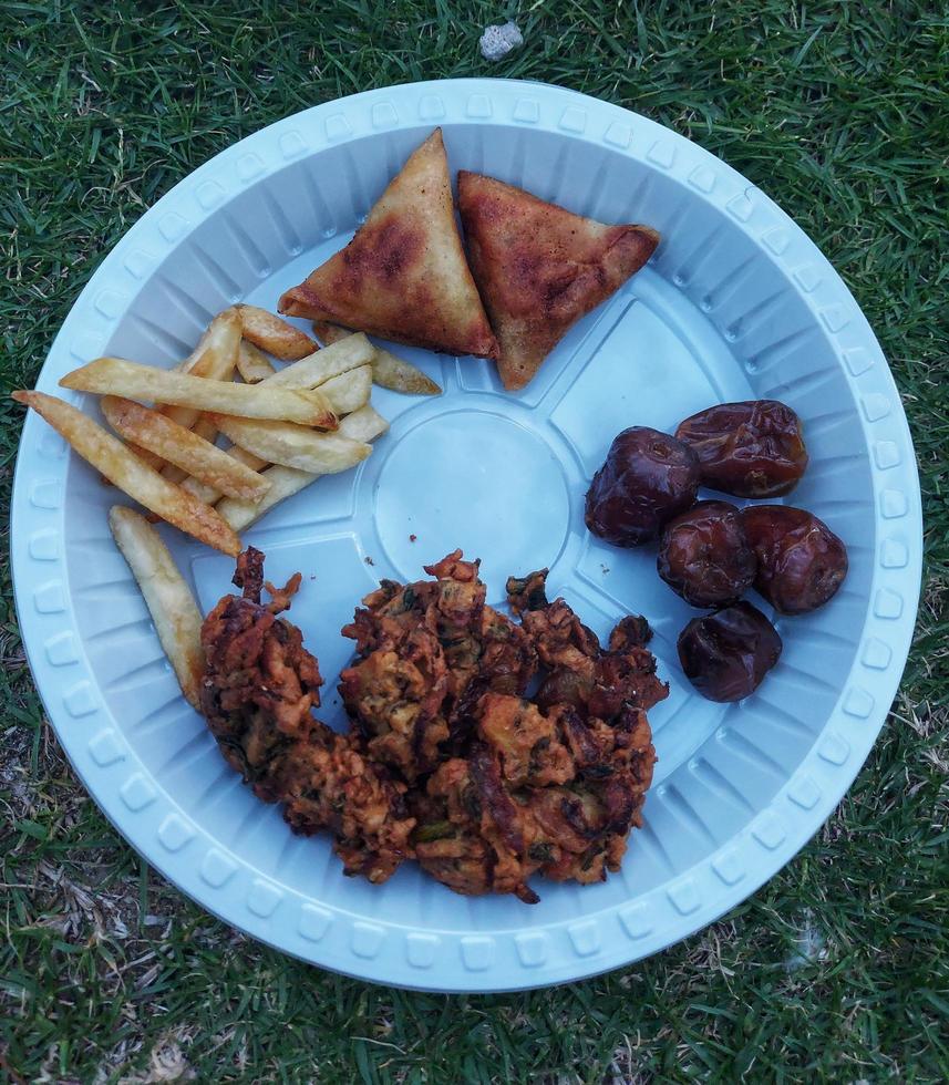 Ramdaan Essen auf Grün Hintergrund im Weiß Teller , Termine und Pommes, Samosa und pokra foto