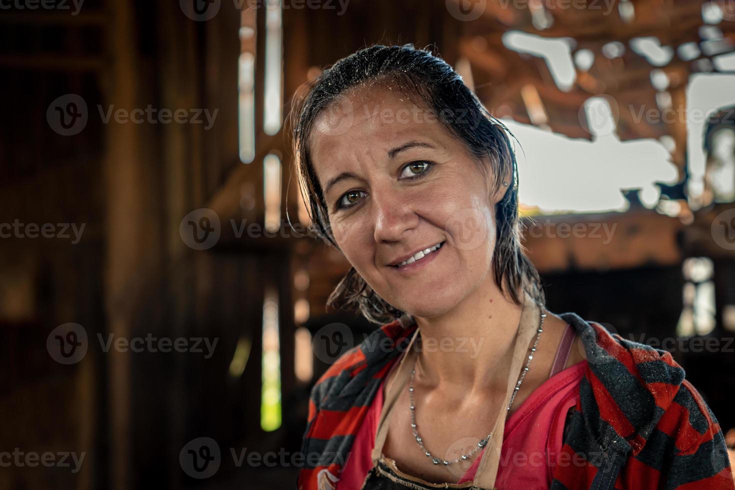 Porträt von ein Erwachsene industriell Frau Arbeiten im ein Sägewerk, suchen beim das Kamera und lächelnd. foto