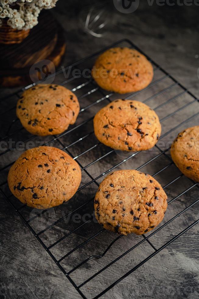 hausgemacht Schokolade Chip Kekse auf schwarz Backen Kühlung Tablett und abstrakt Hintergrund foto