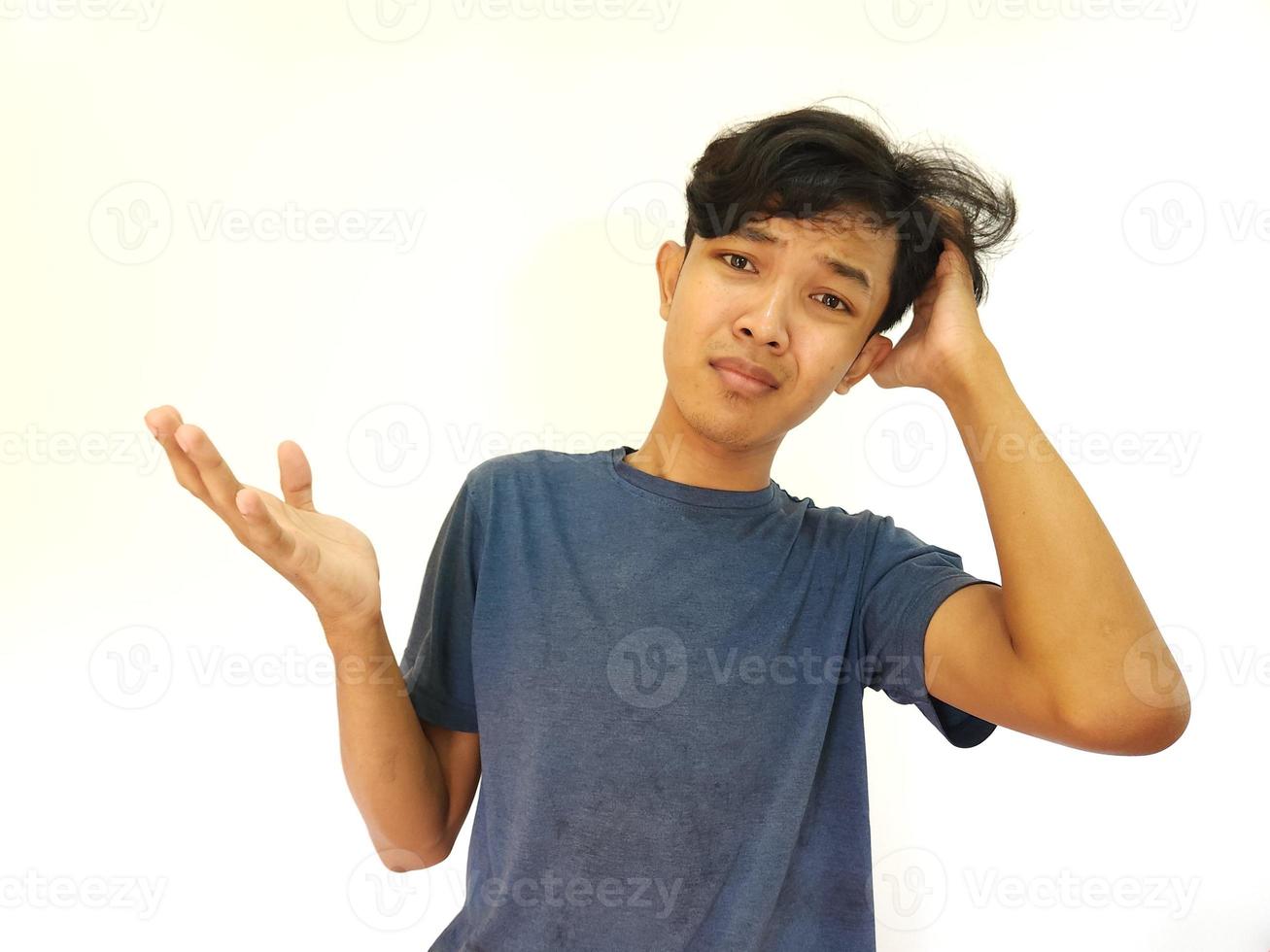asiatisch Mann Kratzen Haar mit verwirrt und ahnungslos Gesicht foto