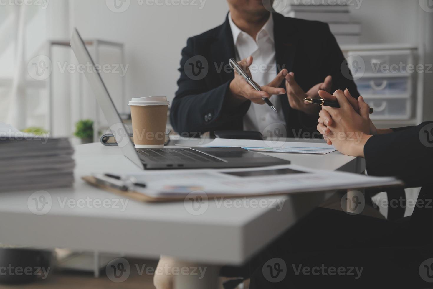 Geschäftsleute. gruppe junger selbstbewusster geschäftsleute, die daten mithilfe des computer analysieren, während sie zeit im büro verbringen foto