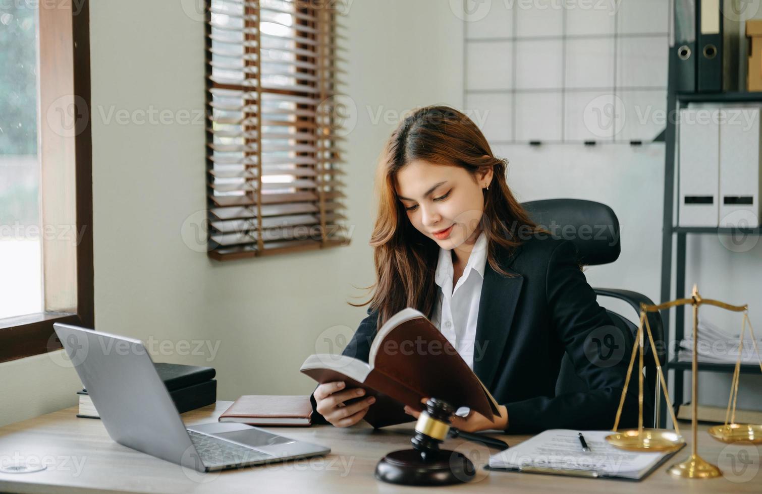 Frau Anwalt lesen legal Buch mit Hammer auf Tabelle im Büro. Gerechtigkeit und Gesetz ,Rechtsanwalt Konzept. foto